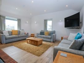 A living room with sofas and a coffee table at Bwthyn Alberts in Trearddur Bay