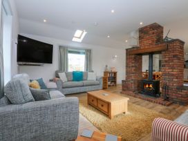 A living room with a fireplace and a sofa at Bwthyn Alberts in Trearddur Bay