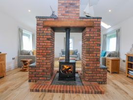 A living room featuring a fireplace and seating area at Bwthyn Alberts in Trearddur Bay