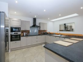 A kitchen with a stove, oven and refrigerator at Bwthyn Alberts, Trearddur Bay