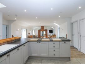 A kitchen with an island and fireplace at Bwthyn Alberts in Trearddur Bay