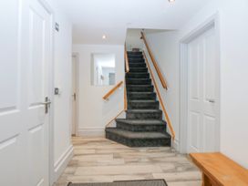 A hallway with stairs and doors at Bwthyn Alberts in Trearddur Bay