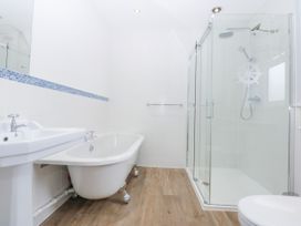 A bathroom with a bathtub, shower, sink, and toilet at Bwthyn Alberts in Trearddur Bay