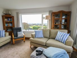 A living room with a sofa and bookcase at Yr Orsedd in Llanfaethlu
