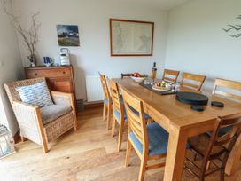 A dining room with a table, chairs, and a side table at Yr Orsedd in Llanfaethlu