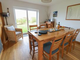 A dining room with a table and chairs at Yr Orsedd in Llanfaethlu