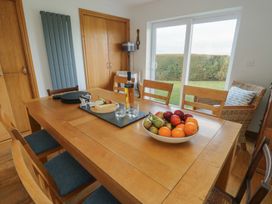A dining room with a table set with fruit and drinks at Yr Orsedd Llanfaethlu
