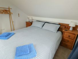 A bedroom with a bed and bedside table at Yr Orsedd in Llanfaethlu
