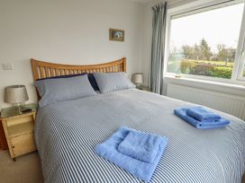 A bedroom with a bed and towels at Yr Orsedd in Llanfaethlu