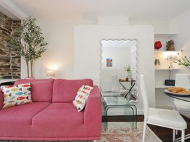 A living room with a pink sofa and a dining table at Stargazy in Trebarwith Strand near Tintagel