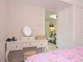 A bedroom with a vanity table and doorway to another room at Stargazy in Trebarwith Strand near Tintagel