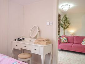 A bedroom with a vanity table and couch at Stargazy Trebarwith Strand near Tintagel