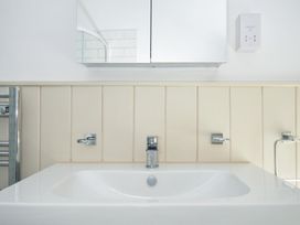 A bathroom with a sink and mirror at Stargazy in Trebarwith Strand near Tintagel