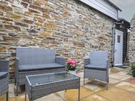 An outdoor seating area with a table and chairs at Stargazy in Trebarwith Strand near Tintagel