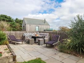 An outdoor seating area with chairs and table at Idlewild, 2 Wheal Turnavore, St Agnes