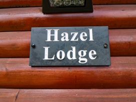 A sign displaying the name Hazel Lodge on a wooden wall at Ryedale Country Lodges - Kirkbymoorside
