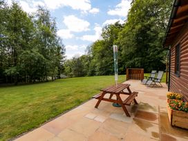 A garden with a table, chairs and a flower box at Ryedale Country Lodges - Hazel Lodge Kirkbymoorside