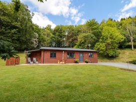 A wooden cabin with chairs and grass area at Ryedale Country Lodges - Hazel Lodge Kirkbymoorside