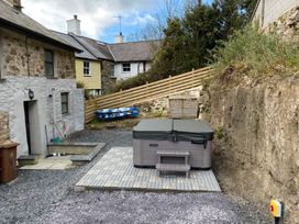 A hot tub and paved area with gravel at The Cottage in Llaniestyn