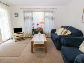 A living room with a sofa and coffee table at Castell Chalet Penrhos near Pwllheli