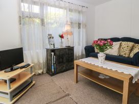 A living room with a sofa and a coffee table at Castell Chalet in Penrhos near Pwllheli
