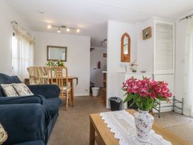 A living room with a sofa and dining table at Castell Chalet in Penrhos near Pwllheli