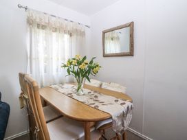A dining room with a table and chairs at Castell Chalet in Penrhos near Pwllheli