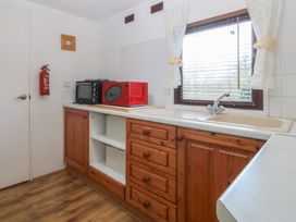 A kitchen with a sink and appliances at Castell Chalet Penrhos near Pwllheli