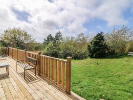An outdoor area with decking and a chair at Castell Chalet Penrhos near Pwllheli