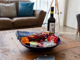 A bowl with snacks and a wine bottle on a table at Cowslip in Bamburgh