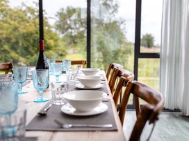 A dining room setup with a table and chairs at Cowslip in Bamburgh