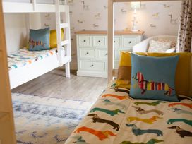 A bedroom with bunk beds and a dresser at Cowslip in Bamburgh