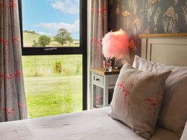 A bedroom with a view and soft furnishings at Cowslip in Bamburgh
