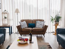A living room with a sofa, table and lamp at Betony in Bamburgh