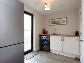 A utility room with a refrigerator, washing machine, and sink at Betony in Bamburgh