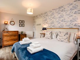 A bedroom with a bed and wall art at Betony in Bamburgh