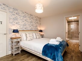 A bedroom with a bed and ensuite bathroom at Betony in Bamburgh