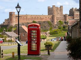 A telephone box with a castle in the background at Betony in Bamburgh