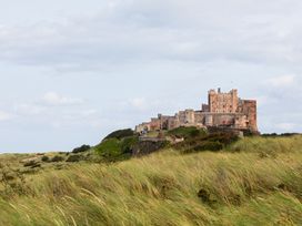 A castle on a hill surrounded by grass at Betony in Bamburgh
