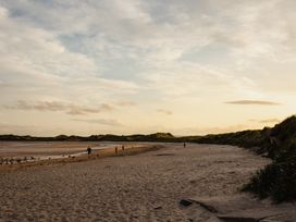 A beach with people walking at Betony in Bamburgh