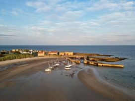 A view of boats at a pier along the beach at Betony in Bamburgh