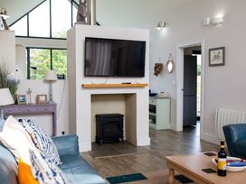 A living room with a television above a fireplace at Betony in Bamburgh