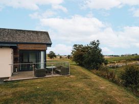 A house with a deck and furniture at Betony in Bamburgh