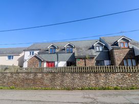 A house with a stone wall and a fence at Sunflower Cottage in St Issey