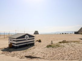 A beach with a hut and ocean view at Swallow Cottage in Sticker