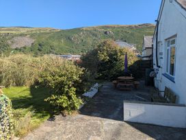A garden with a table and bench at Minydon in Fairbourne