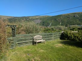 A garden with a bench and a fence at Minydon in Fairbourne