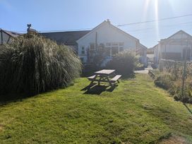 A garden with a picnic table and green grass at Minydon in Fairbourne