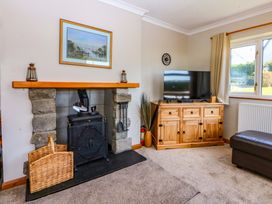 A living room with a fireplace and television at Pen Y Garth Mynytho near Llanbedrog