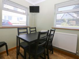 A dining room with a table and chairs at Pen Y Garth Mynytho near Llanbedrog